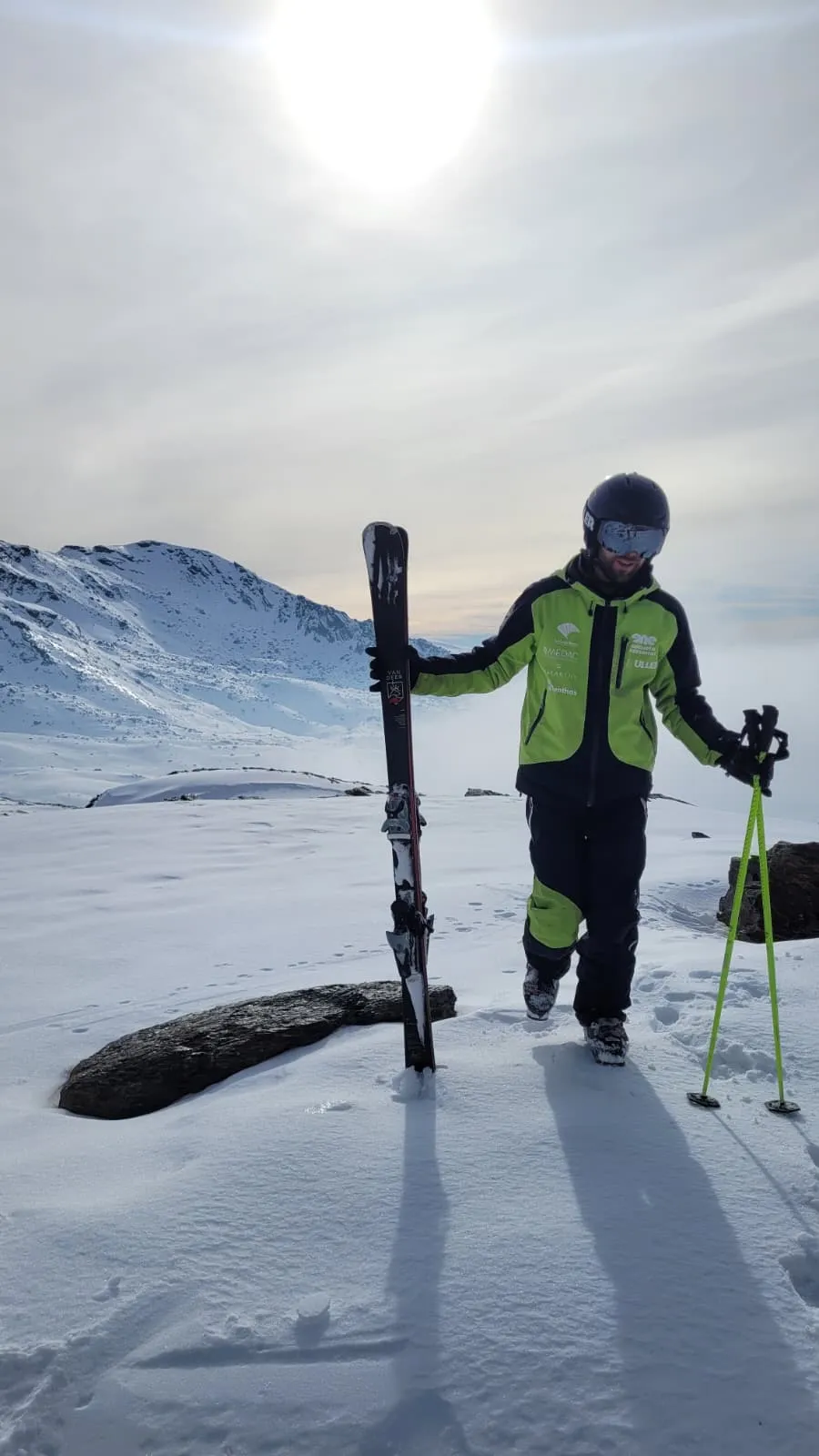 Pedro con esquís en la mano y en la montaña